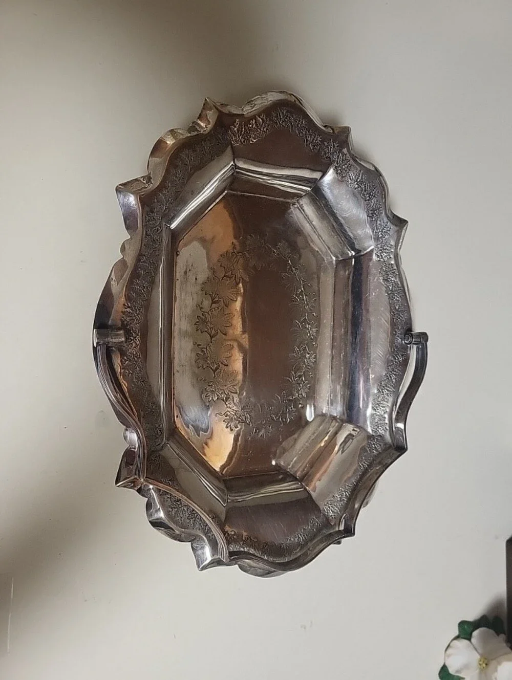 Silver-plated decorative tray with ornate scalloped rim and handles,
